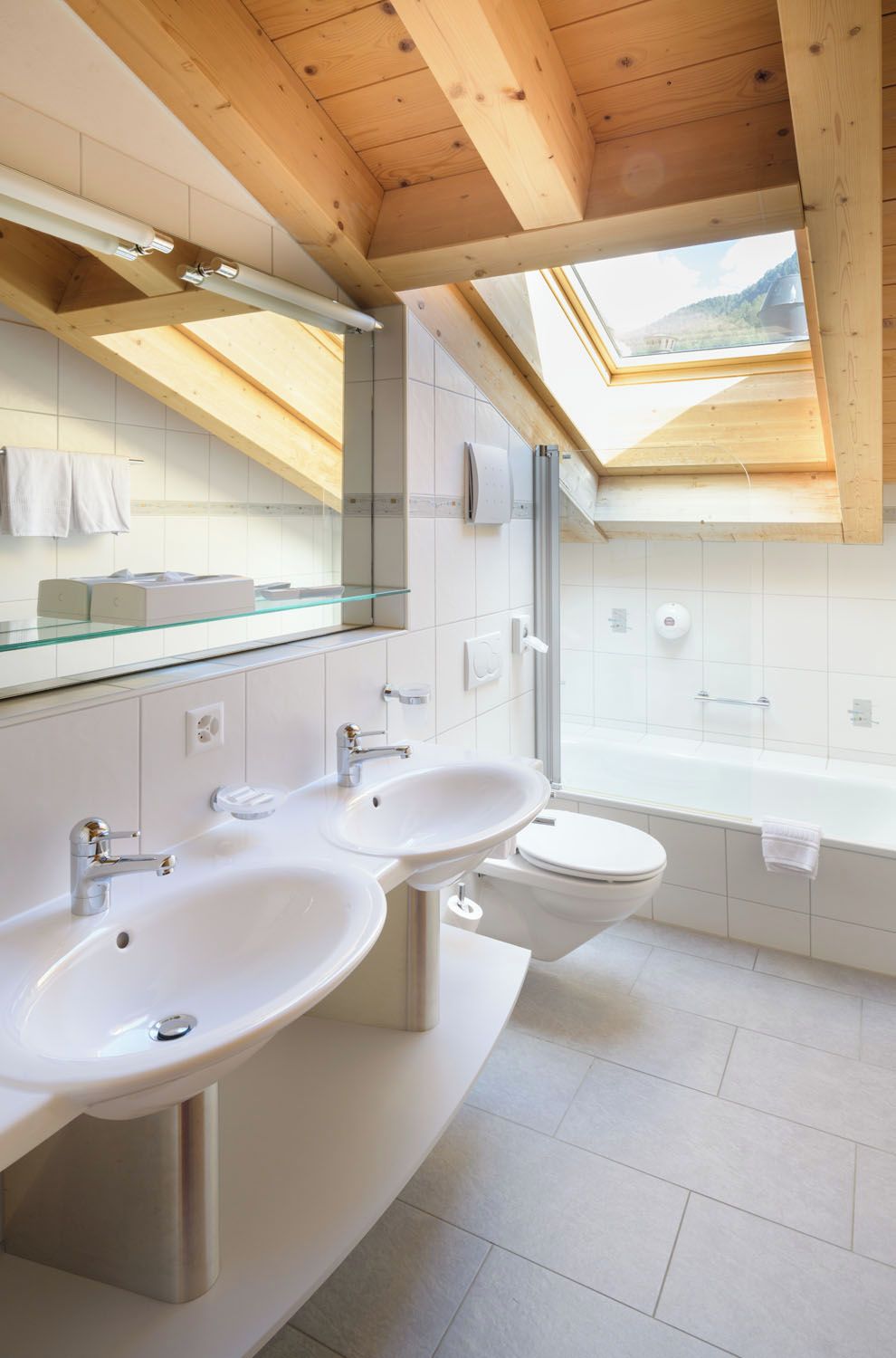 Un baño moderno con dos lavamanos, inodoro y bañera.