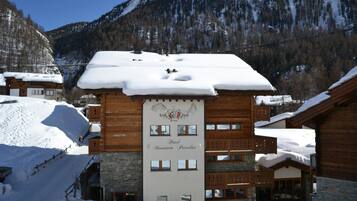 Una cabaña de madera estilo lodge en la montaña, con un letrero que dice 'Hotel Mountain Paradise'.