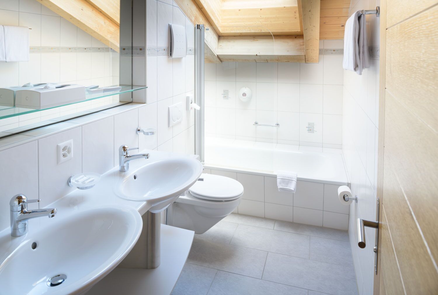 Une salle de bain moderne avec deux lavabos, des toilettes et une baignoire.