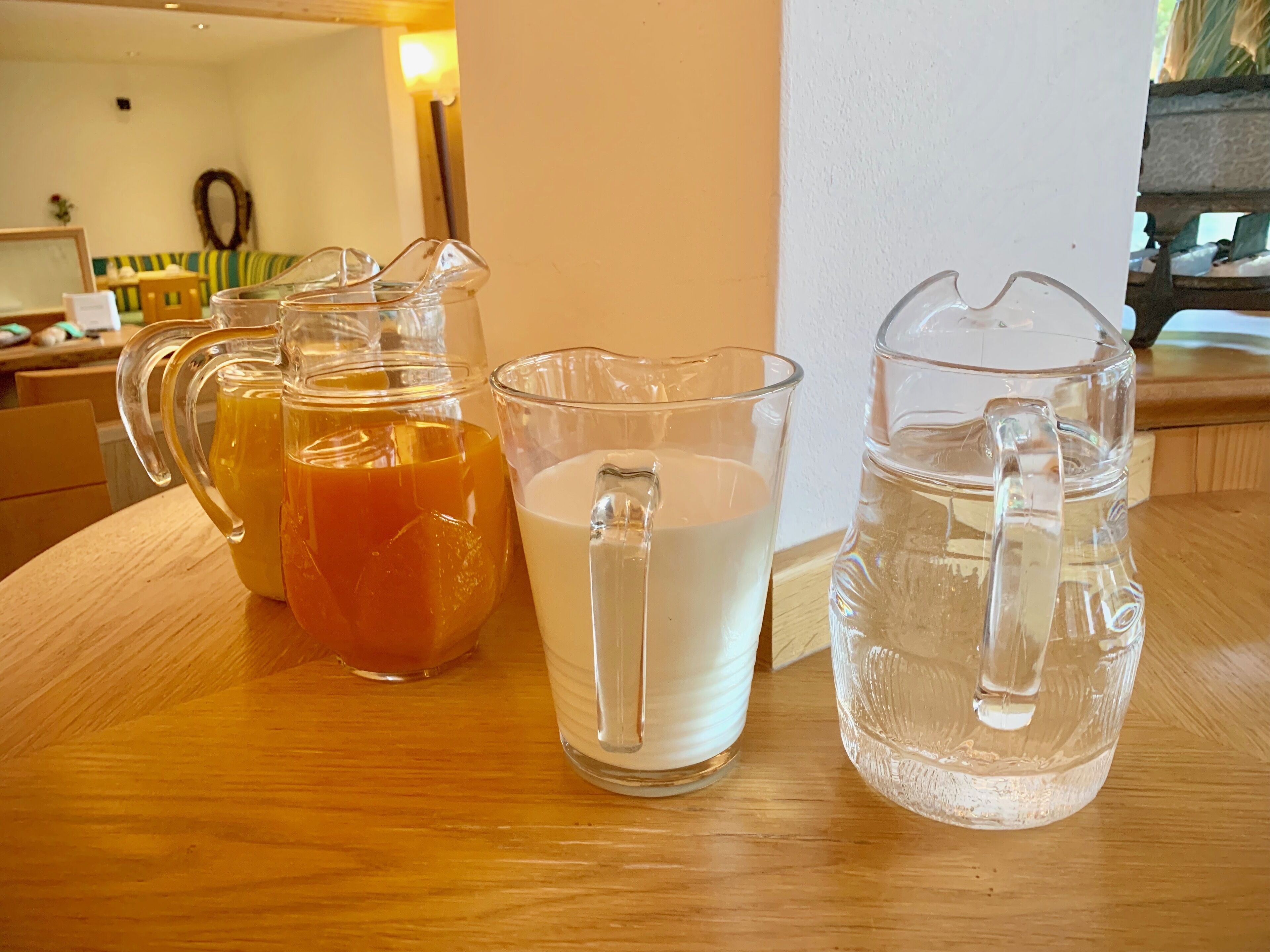 Drie glazen kannen op een houten tafel.