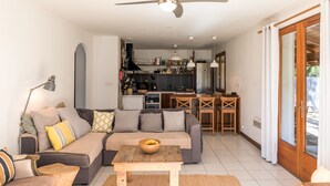A modern living room with a sofa, a coffee table, and a dining area with a table and chairs.