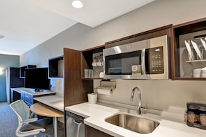 A compact kitchenette with a microwave, sink, and a small dining area. - Home2 Suites by Hilton Palmdale, CA (Palmdale)