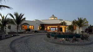 A modern house with a circular driveway, palm trees, and a fountain. - Casa Cardonal - El Cardonal, BCS Mexico (El Cardonal)