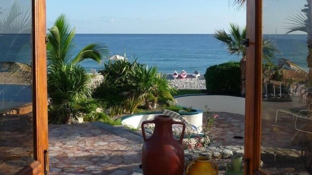 An open doorway with a view of a beach and palm trees. - Casa Cardonal - El Cardonal, BCS Mexico (El Cardonal)