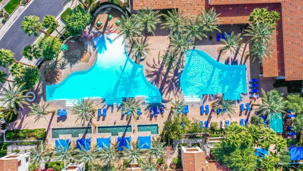 An aerial view of a resort with a large swimming pool, palm trees, and sun loungers. - Have Fun and Relax at Luxury Legacy Villa. Family Friendly or Great for Couples! (La Quinta)