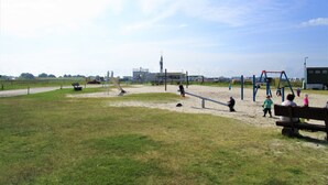 A playground with various play equipment, a bench, and a clear sky. - Spacious vacation residence for 6 pers. with pool and garden. Sauna - shared use (Stadland-Reitland)