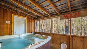 Una cabaña de madera con un jacuzzi, un letrero que dice 'LET'S DO SUNSET' y una puerta con un letrero que indica 'NOT TO BE OPENED'.