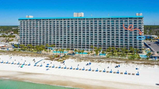 A large hotel with multiple floors, a pool area, and a beach with sun loungers. - Gulf-Front Comfort, Personally Prepared for You (Panama City Beach)