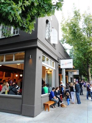 A restaurant with outdoor seating, a sign reading "Salt & Straw," and a crowd of people outside.