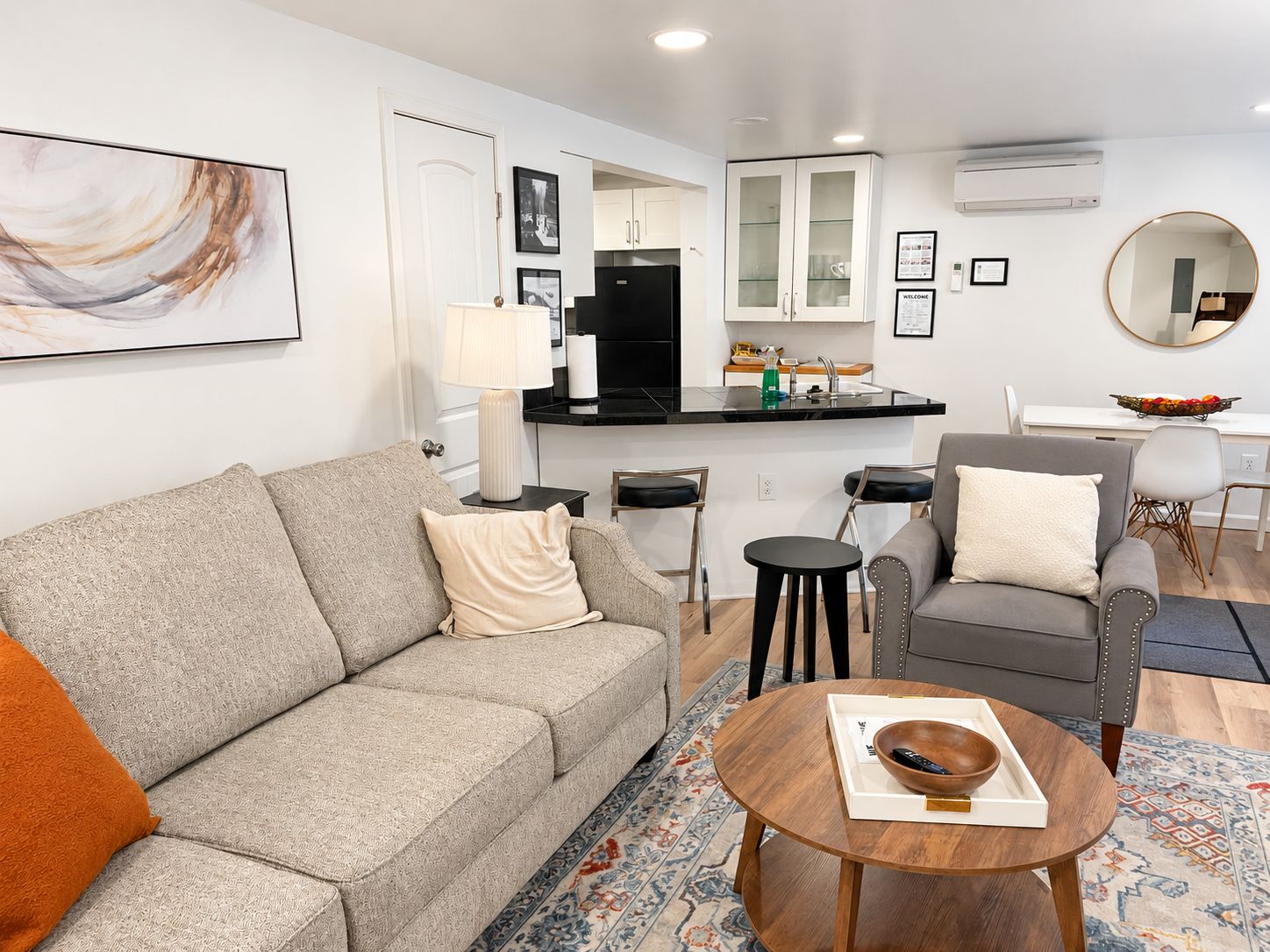 A modern living room with a sofa, a coffee table, and a dining area with chairs.