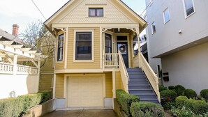 A two-story house with a front porch, a garage, and a staircase leading to the second floor.