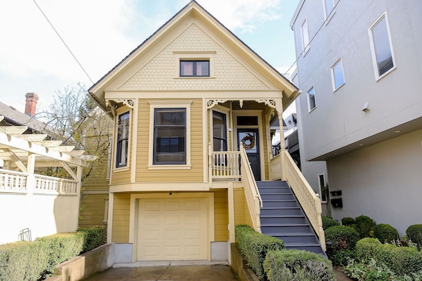 A two-story house with a front porch, a garage, and a staircase leading to the second floor.