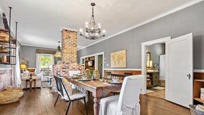 A spacious living room with a fireplace, dining area, and a view of the outdoors.