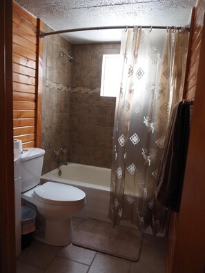 Een badkamer met toilet, wastafel en bad.