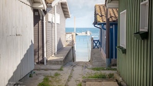 Un sentiero stretto che porta a un molo con vista sul mare.