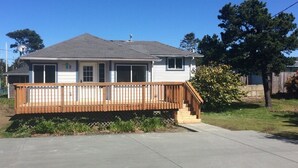 A single-story house with a wooden deck and a covered front porch. - BRIGHT! 1.5 Blocks to Beach - Light Filled House (3 Bedroom Plus Den)  (Seaside)