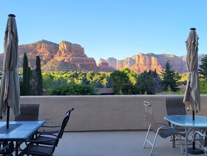 An outdoor patio with a table and chairs, a glass-top table, and two umbrellas. - BEST VIEWS! Balcony, Firepit, Lawn, Patio, Wildlife (Sedona)
