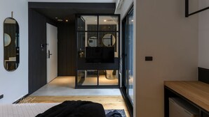 A modern bedroom with a large bed, a TV, and a walk-in closet. - Hido Hotel I (Hengchun)