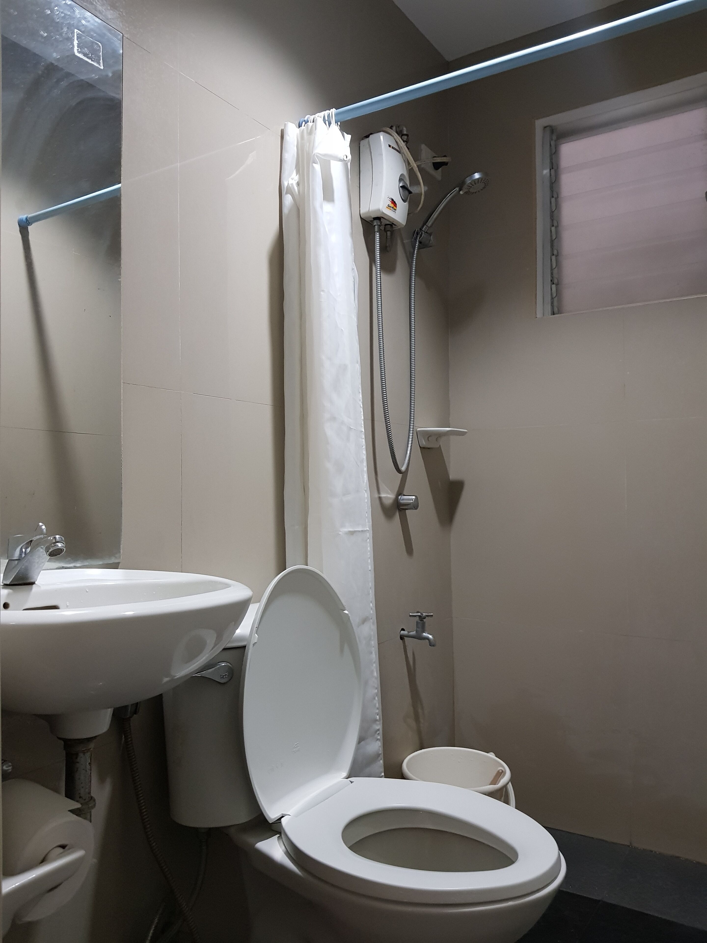 A bathroom with a toilet, sink, and shower.