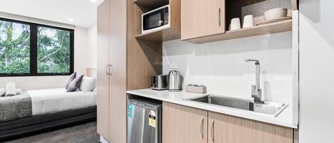 A modern kitchen with wooden cabinets, a built-in microwave, and a stainless steel dishwasher.