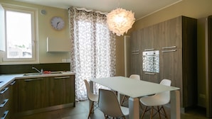 A modern kitchen with a dining table, chairs, and a clock on the wall. - Veronaforent Casa Myriam (Verona)