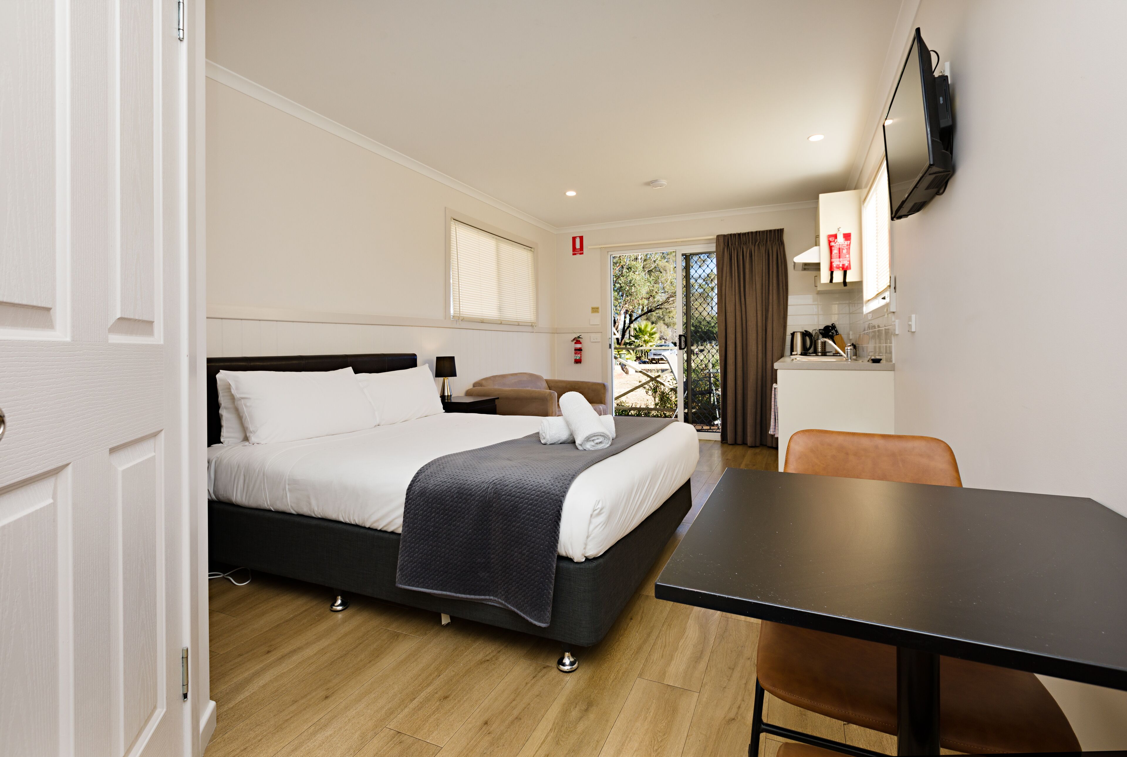 Une chambre d’hôtel avec un lit, une table et un téléviseur.
