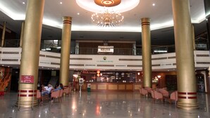 A spacious lobby with a chandelier, large columns, a reception desk, and a staircase. - JP Emerald Hotel (Yasothon)