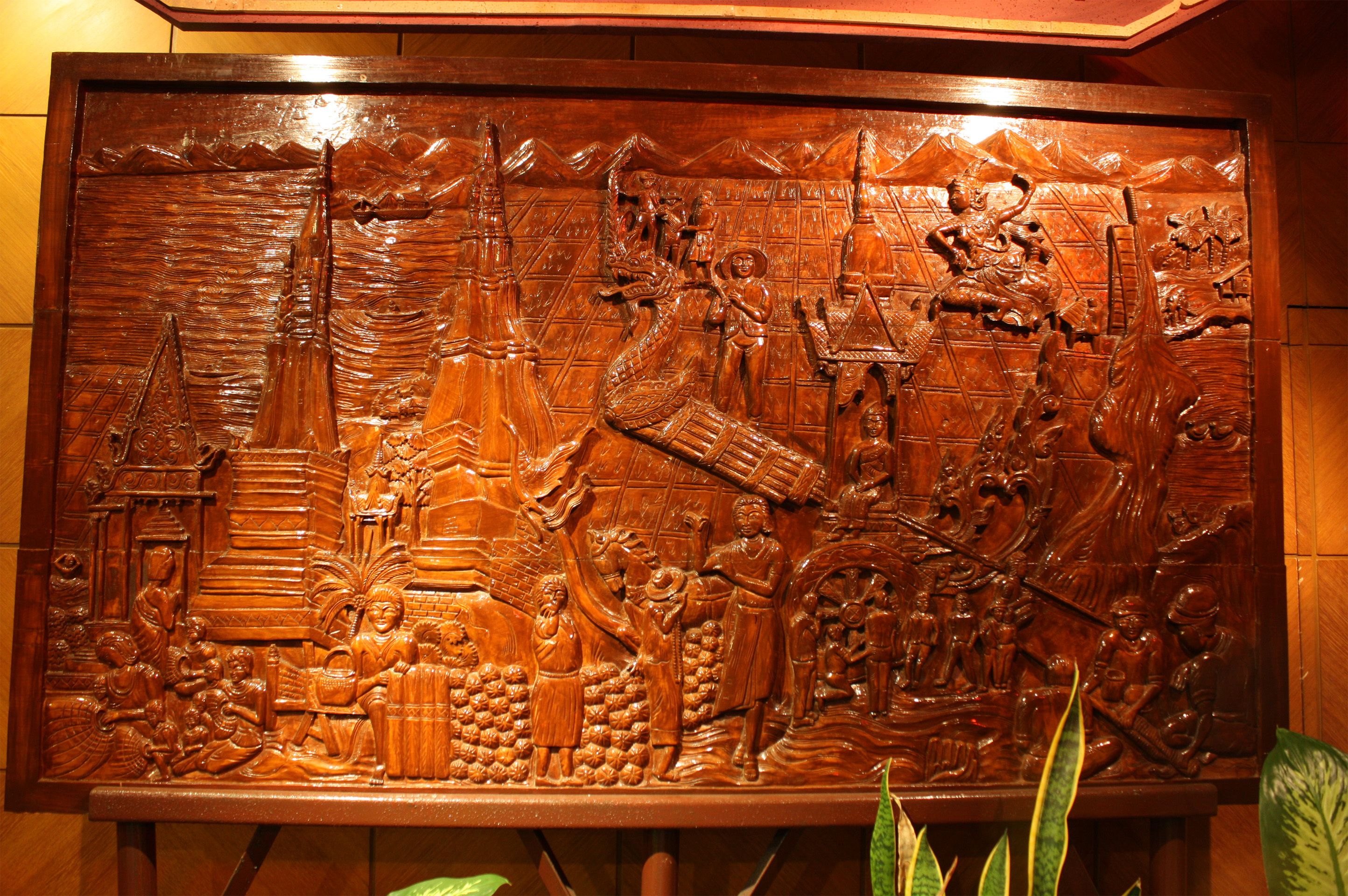 A detailed wooden carving with figures and structures.
