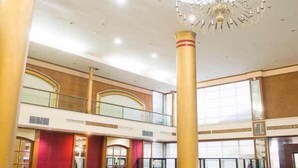 A spacious interior with a high ceiling, a grand chandelier, and a double-height atrium. - JP Emerald Hotel (Yasothon)