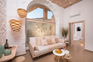 Un salon moderne avec un canapé, une table à manger et une grande fenêtre.