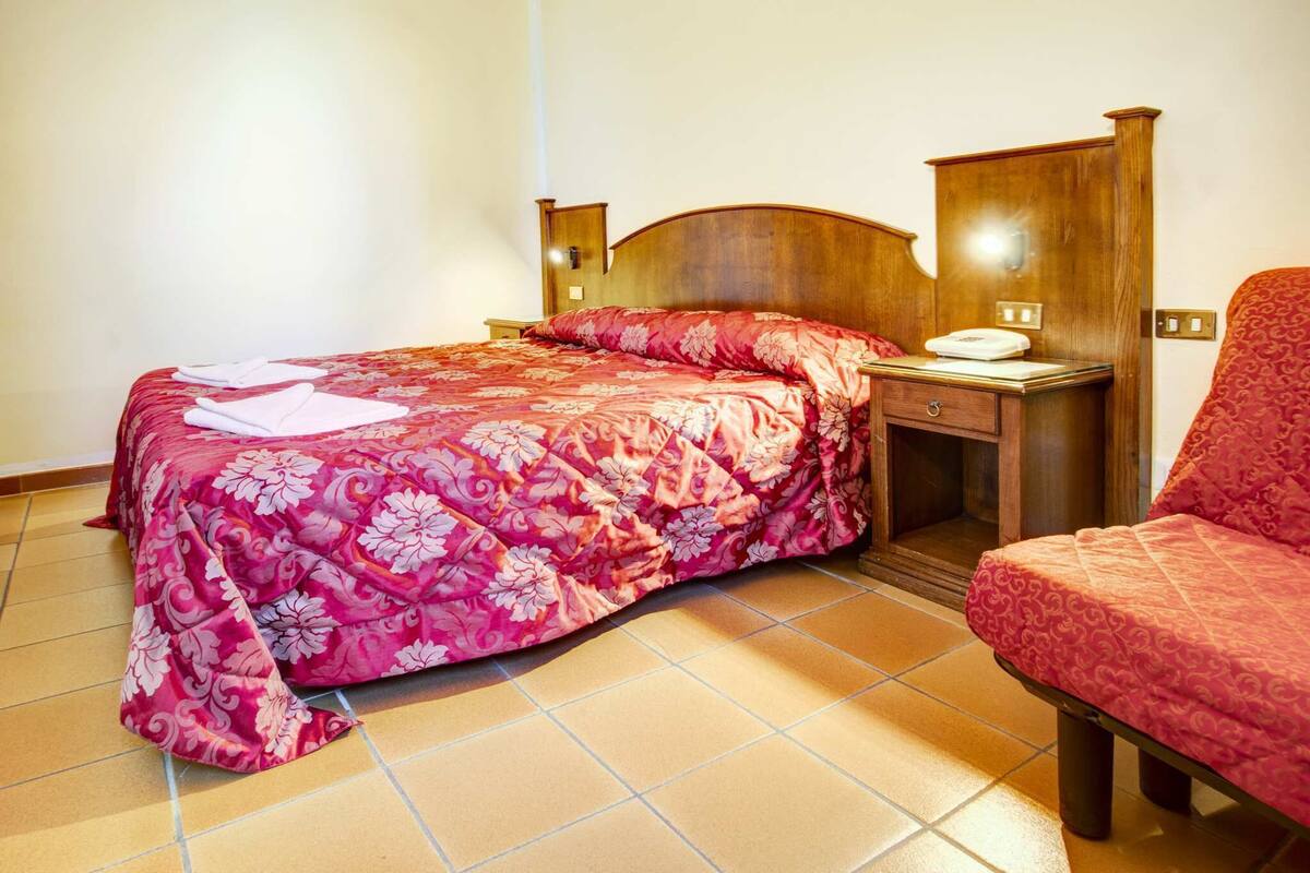 Une chambre à coucher avec un lit, une table de chevet et une chaise.