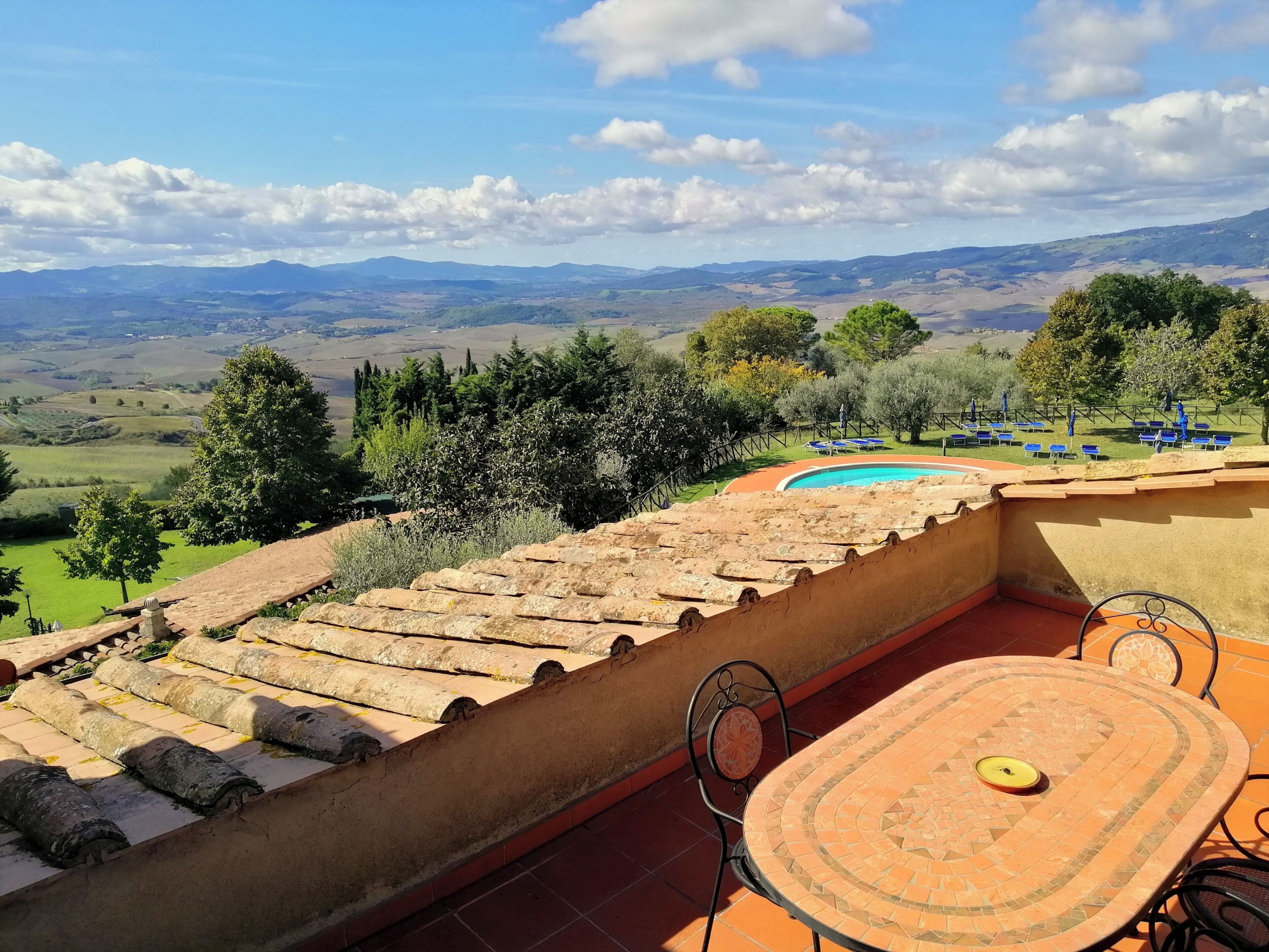 Una terraza con vistas a ondulantes colinas y una piscina.