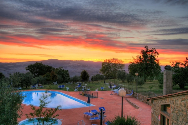 Una piscina al aire libre de temporada, sombrillas, tumbonas