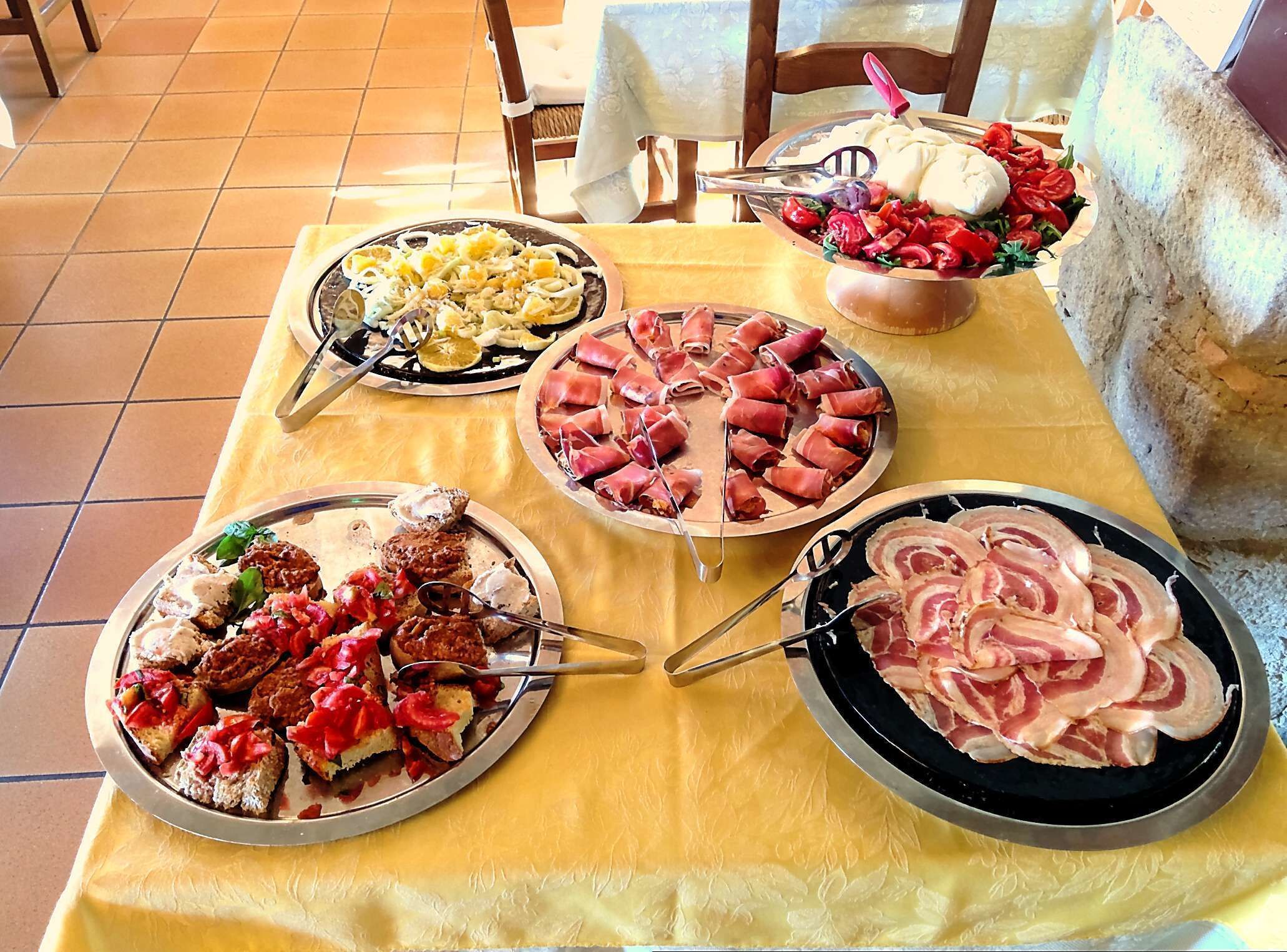 Et bord med forskelligt mad, blandt andet pasta, lufttørret kød og grøntsager.
