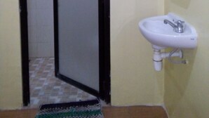 A bathroom with a white sink, a mirror, and a tiled floor. - Ekost Danurejan (Yogyakarta)