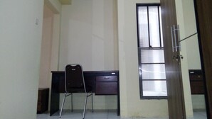 A room with a desk, chair, and a window with blinds. - Ekost Danurejan (Yogyakarta)