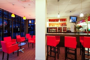 A bar area with red chairs and a counter. - Comfort Hotel Montlucon (Montlucon)