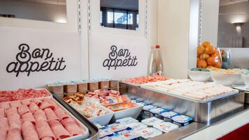 A buffet with various food items including meats, cheeses, and fruits.