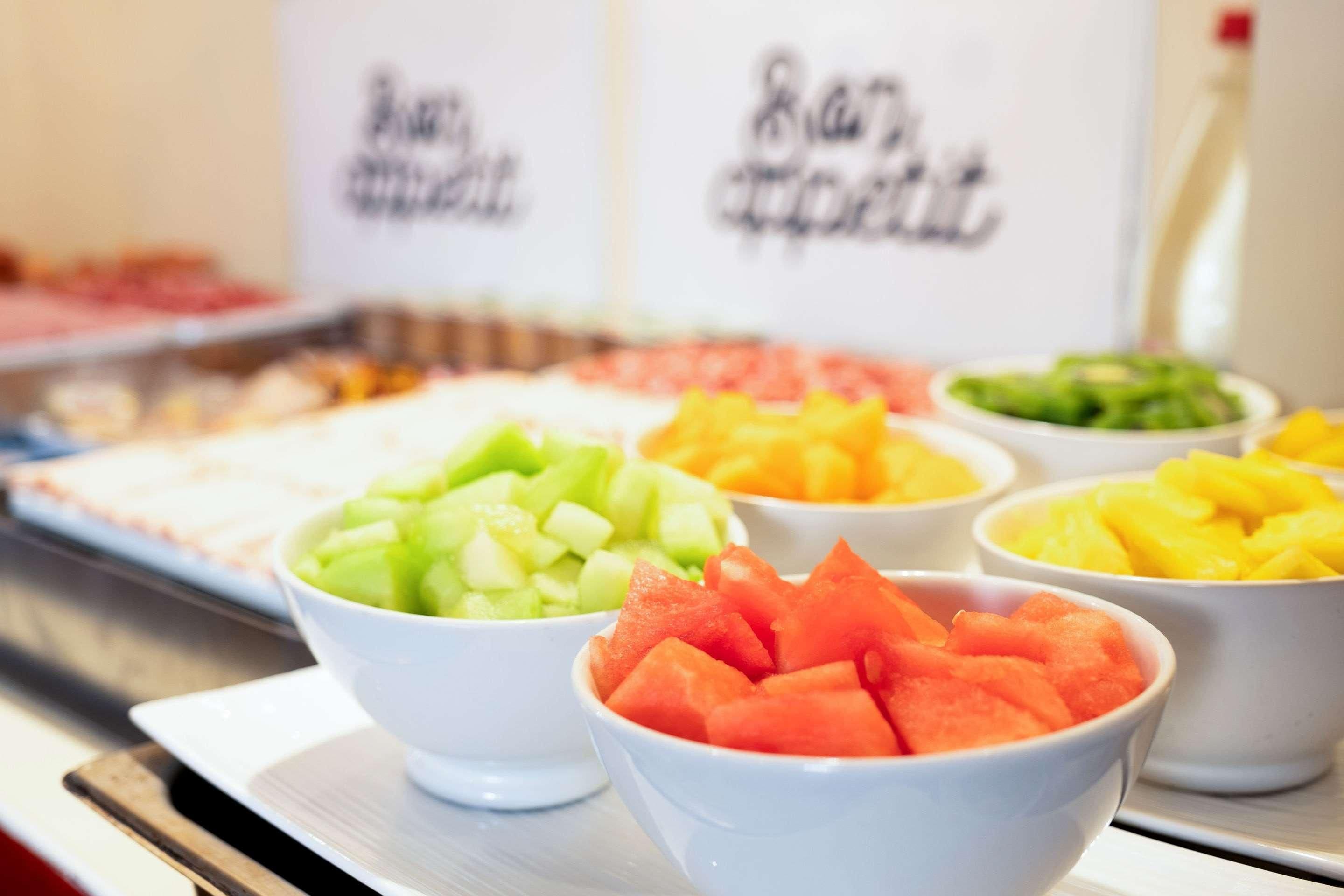 Un bufé con diversas opciones de fruta en cuencos.