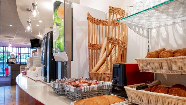 Un buffet de petit-déjeuner comprenant du pain, des viennoiseries et une machine à café.
