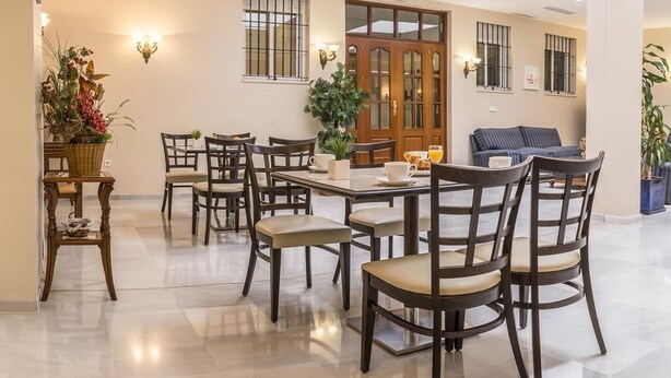 A dining area with a rectangular table, multiple chairs, and a wooden door with glass panels.