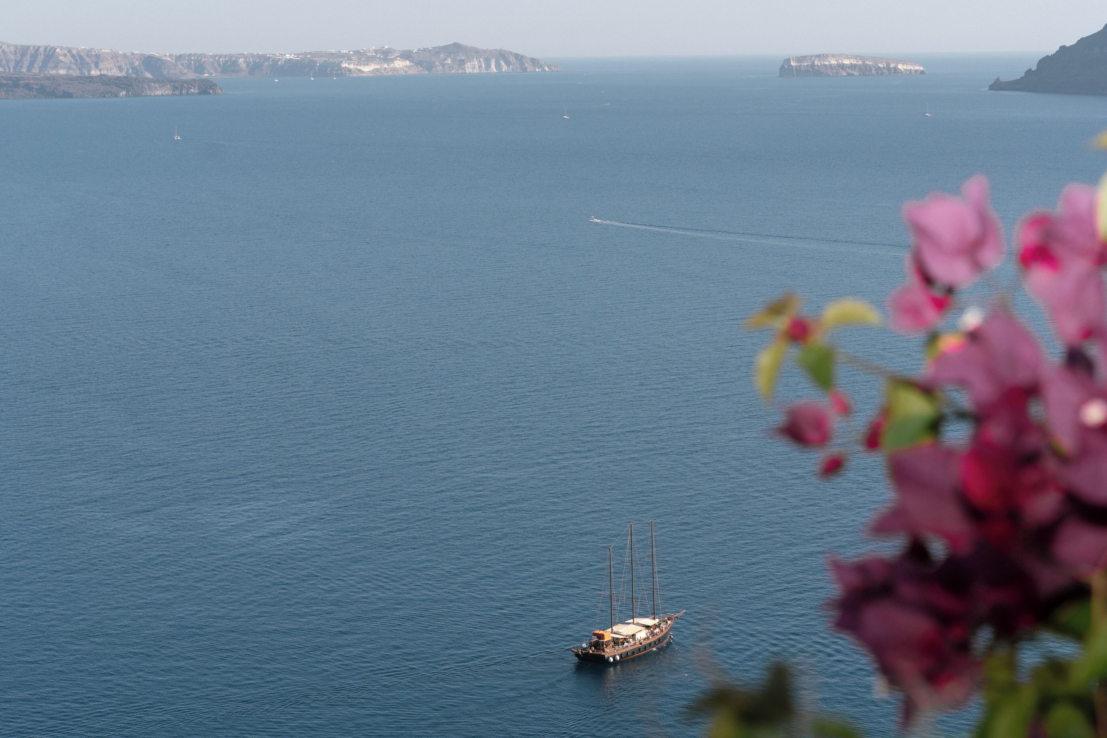 A boat on calm waters with distant landforms.