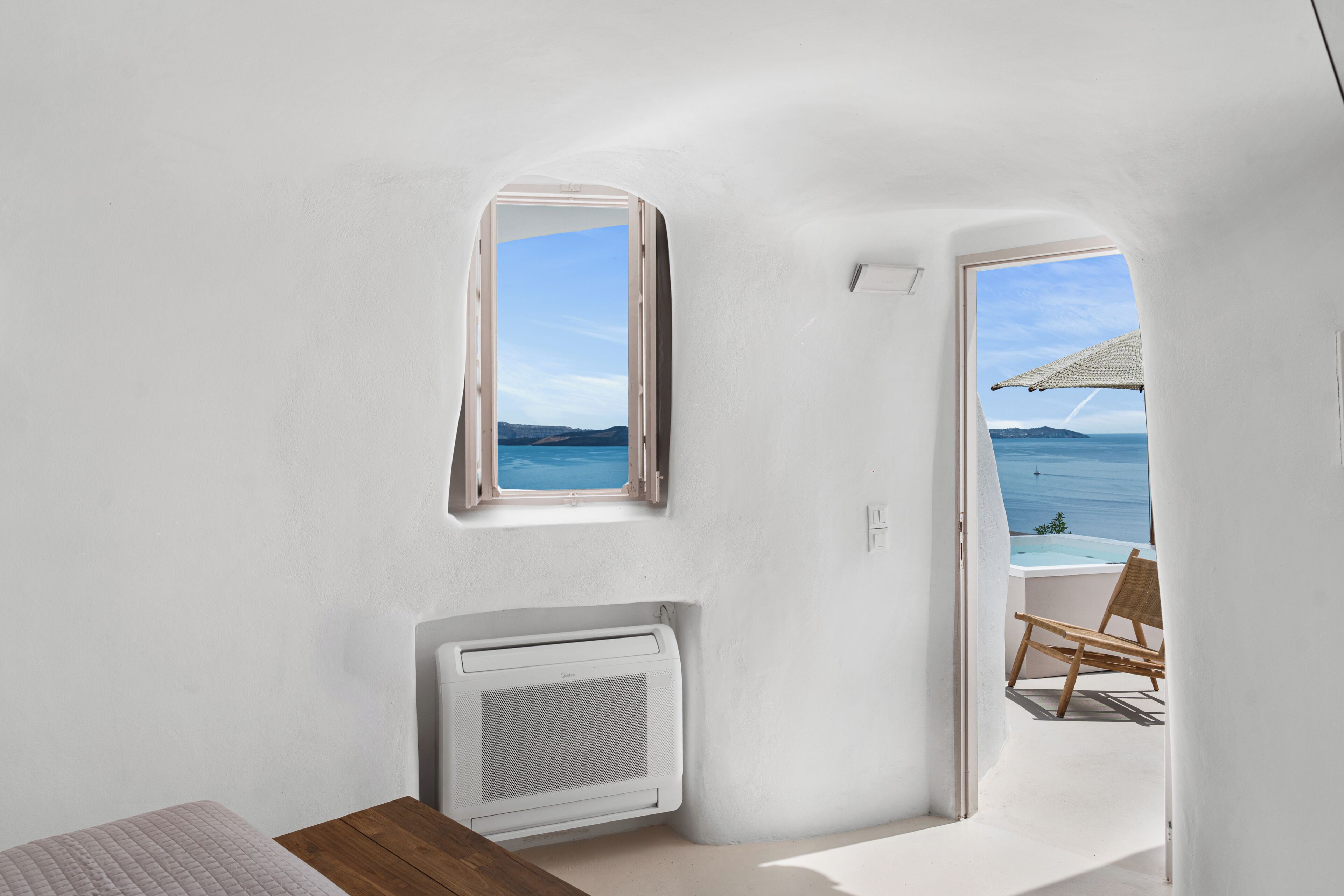 Une pièce avec vue sur la mer, une fenêtre, un radiateur et une table en bois.