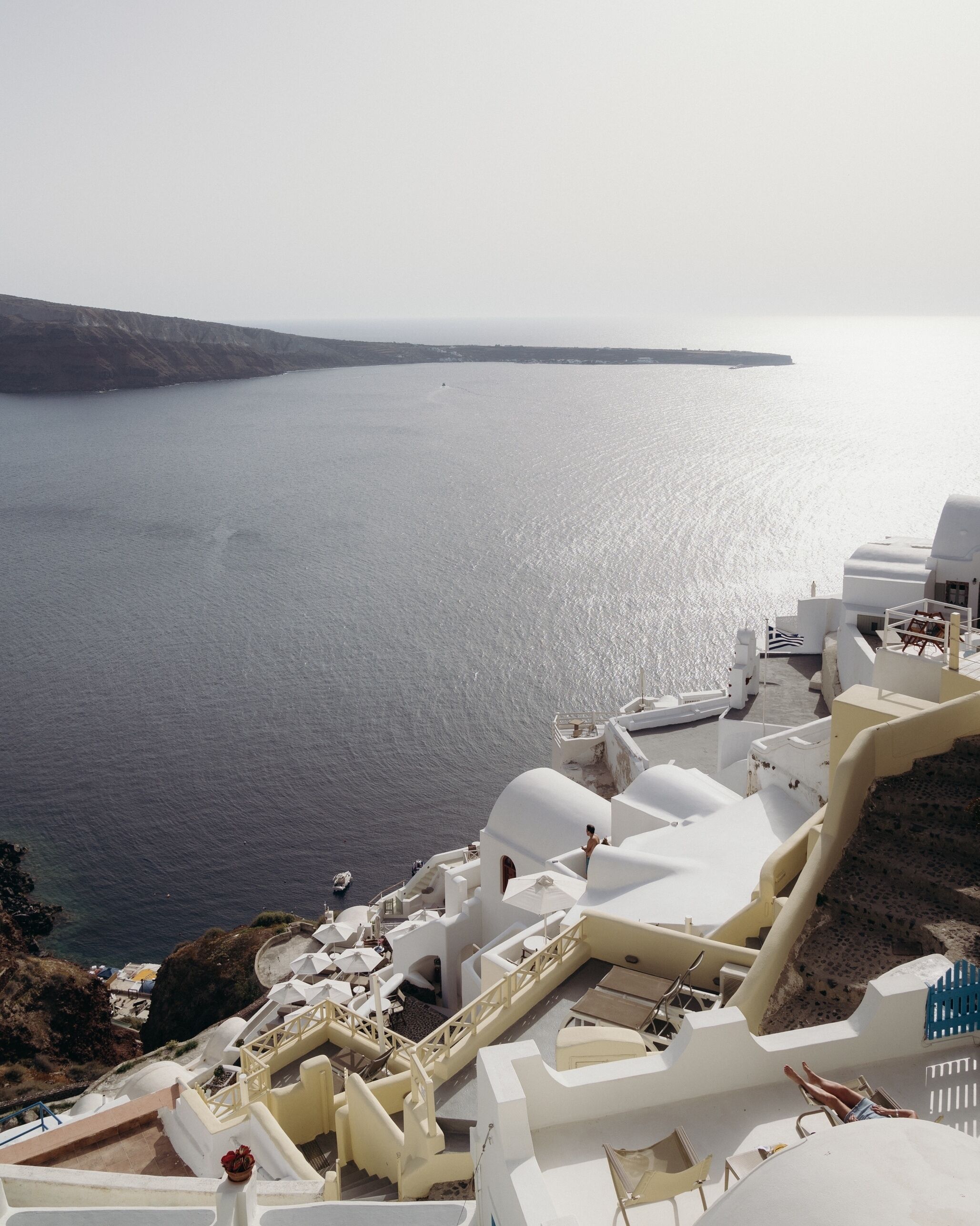 A coastal building with white architecture, a staircase, and a view of the sea.