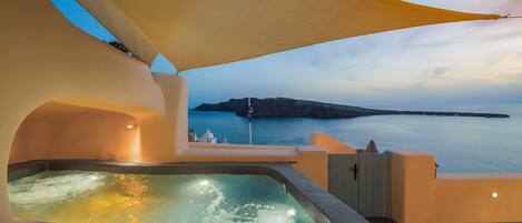A hot tub with a view of the sea and a distant island.