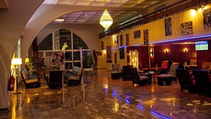 Un hall d’entrée spacieux avec un plafond haut, un lustre et des coins salon.