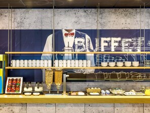 Een buffet met een groot spandoek, diverse opdienposten en een ruime keuze aan eten en drinken.
