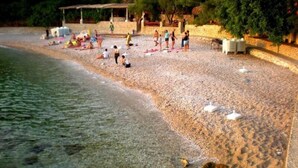 A beach with people sunbathing and swimming. - Villa Panorama (Zupa dubrovacka)