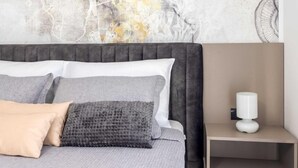 A bedroom with a bed, pillows, a nightstand, and a wall art piece. - Villa Panorama (Zupa dubrovacka)