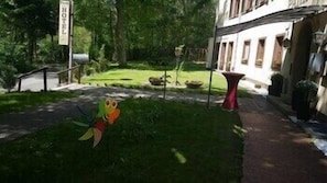 A hotel with a grassy lawn, a red table, and a signboard. - Park-hotel Zirndorf (ZIRNDORF)